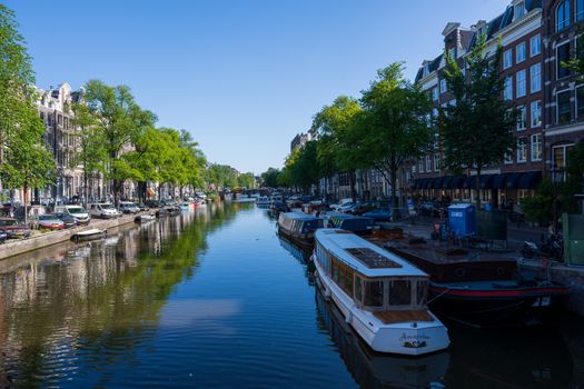 Amsterdam, the Netherlands — July 30, 2019. Photo of tour boats on the Herengracht canal in late morning.