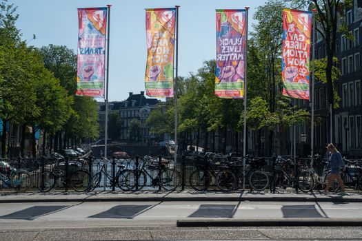 Amsterdam, the Netherlands — July 30, 2019. Protest flags fly over a canal bridge in Amsterdam on a late summer morning.