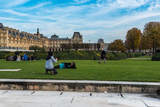 Paris, France -- November 3, 2017 -- Woman poses for a photo on the grass in a park.