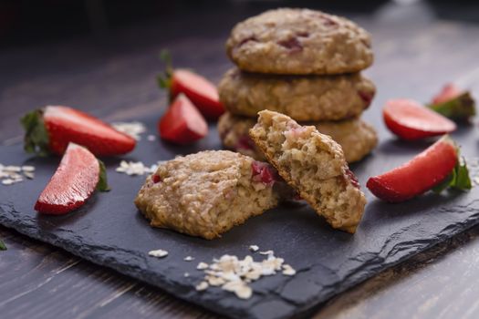 Homemade strawberry oatmeal cookies on black stone slate 