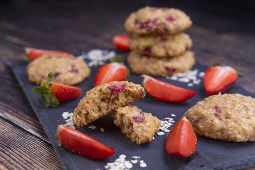 Homemade strawberry oatmeal cookies on black stone slate 