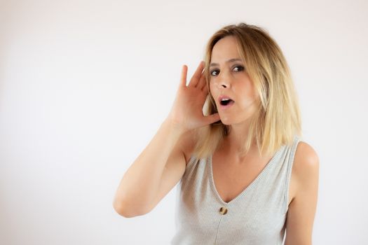 Young woman with short hair wearing a casual dress making the gesture of listening