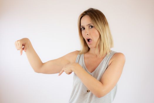 Young woman with short hair wearing a casual dress pointing with her fingers