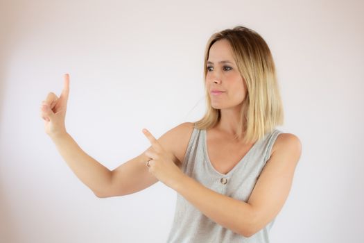 Young woman with short hair wearing a casual dress pointing with her fingers