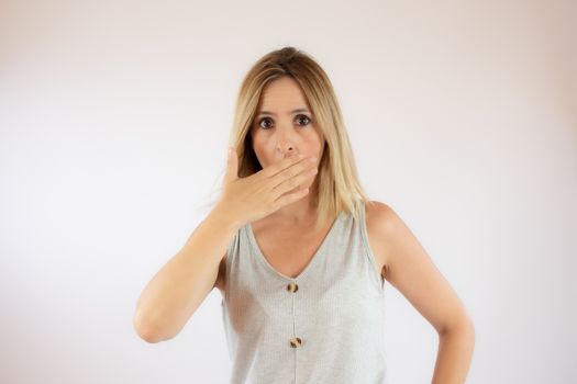 Young woman with short hair wearing a casual dress making surprised gesture