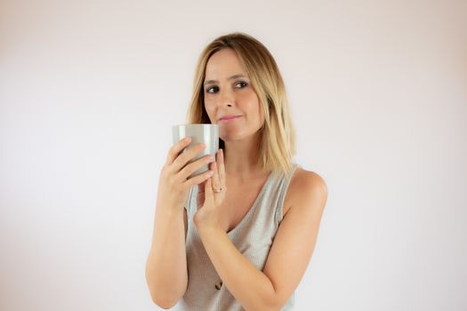 Young woman picking up a cup of coffee