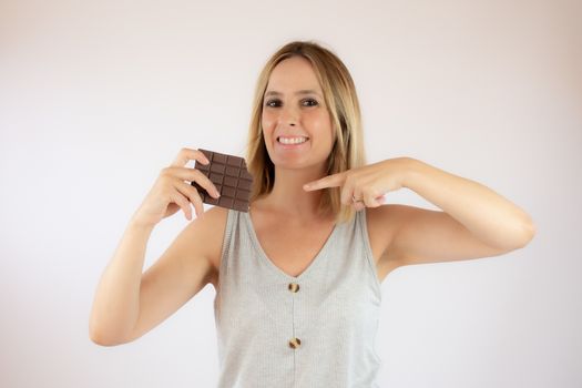 Young woman with short hair showing a piece of chocolate