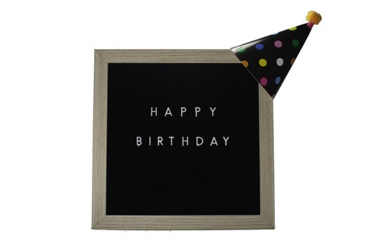 A Birch Framed Sign That Says Happy Birthday in White Letters With a Black Party Hat on Top on a Pure White Background