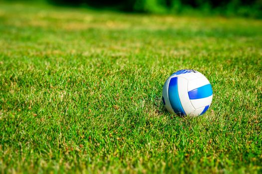 A Blue and White Volleyball in a Dreamy Grass Field in the Summer Time