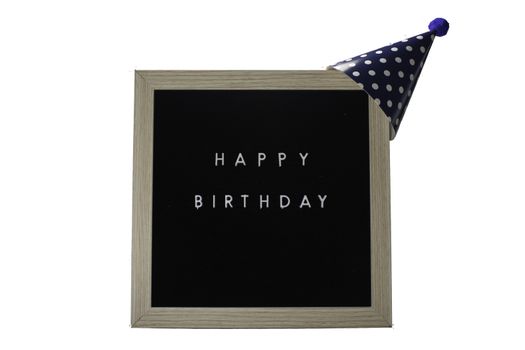 A Birch Framed Sign That Says Happy Birthday in White Letters With a Dark Blue Party Hat on Top on a Pure White Background