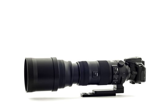 Horizontal shot of a modern DSLR camera with super telephoto zoom lens on a white background.