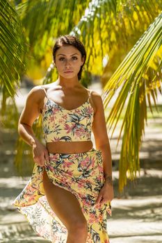 A beautiful brunette model enjoys the soft light under a palm tree in the Yucatán Peninsula near Merida, Mexico