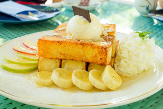 Toast and ice cream are placed on top, paired with bananas and apples.