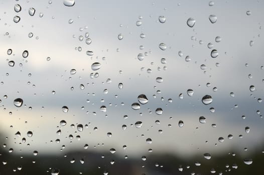 Drops of rain on the window, rainy day. Shallow DOF