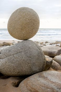 Stone balancing on stone - stone laid on other stone on seacoast