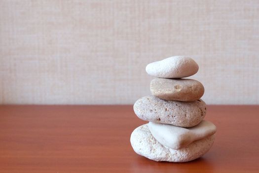 pyramid of round natural stones on a wooden background as a symbol of harmony and balance