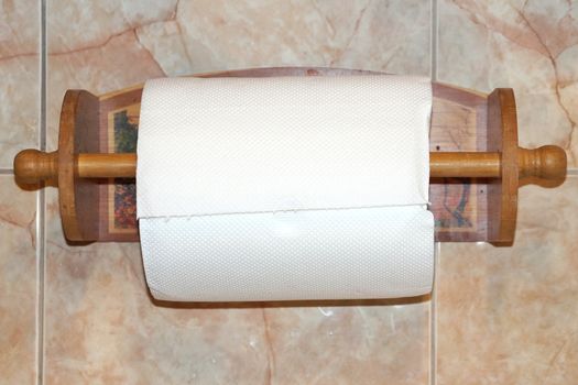 paper kitchen towel on a wooden stand on the wall