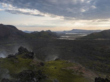 Lava field landscape in Landmannalaugar with and geothermal fumarole, river delta and Rhyolit mountain at Sunrise in Fjallabak Nature Reserve, Highlands Iceland.