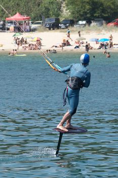 a man is kiting the sea against the background of the beach.