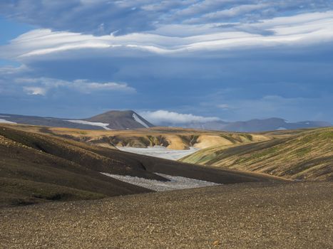 Colorful Rhyolit mountain panorma with snow fiields and multicolored volcanos in Landmannalaugar area of Fjallabak Nature Reserve in Highlands region of Iceland.
