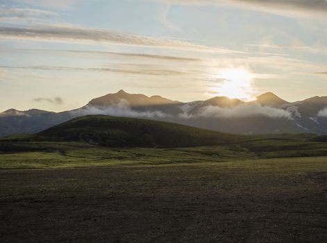 Sunrise at Alftavatn camping site with snow covered mountains and green hills. Landscape of the Fjallabak Nature Reserve in the Highlands of Iceland.