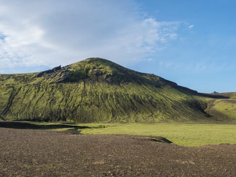 Beautiful green volcanic hill with lush moss and grass near Alftavatn lake. Summer sunny day, landscape of the Fjallabak Nature Reserve in Highlands Iceland part of Laugavegur hiking trail.