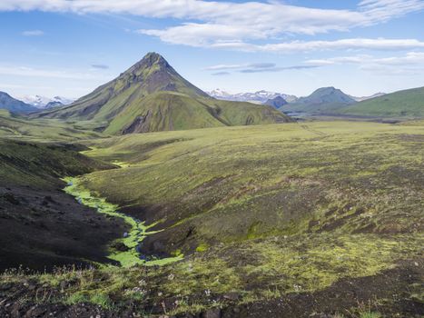 Volcanic landscape of green Storasula mountain with lush moss between Emstrur and Alftavatn camping sites on Laugavegur trek in area of Fjallabak Nature Reserve, Iceland.