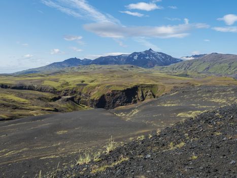 Icelandic lava desert landscape with view on Tindfjallajokull glacier mountain peak. Fjallabak Nature Reserve, Iceland. Summer blue sky.