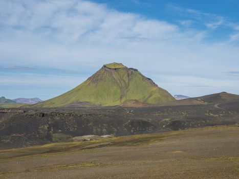 Green Hattafell mountain in volcanic landscape near Emstrur camping site viewed from Laugavegur trail. Area of Fjallabak Nature Reserve in Highlands of Iceland. Summer day, blue sky, copy space