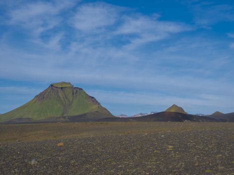 Green Hattafell mountain and panorama of Landmannalaugar colorful mountains. Fjallabak Nature Reserve, Iceland. Summer day, blue sky, copy space..