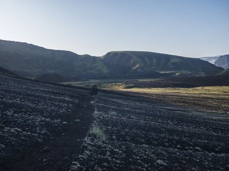 Sunrise view on Myrdalsjokull glacier at Iceland from Laugavegur hiking trail, green valley in volcanic landscape with Early morning pink light.