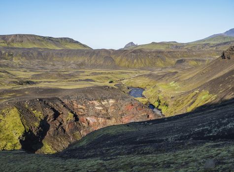 Icelandic landscape with blue Markarfljot river canyon, green hills and Einhyrningur unicorn mountain. Fjallabak Nature Reserve, Iceland. Summer blue sky.