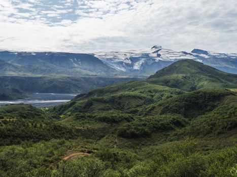 Icelandic landscape with green hills of Thorsmork and eyjafjallajokull volcano glacier. Laugavegur hiking trail. Fjallabak Nature Reserve, Iceland. Summer blue sky.
