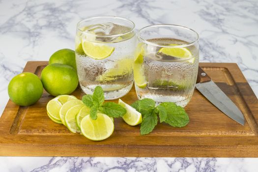 Cold Drink from Lemon cut into pieces in water glass on wood cup