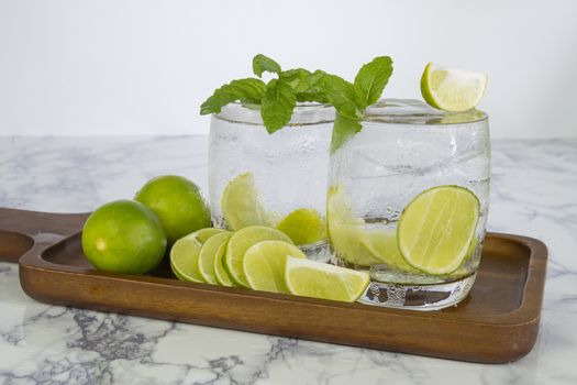 Cold Drink from Lemon cut into pieces in water glass on wood cup
