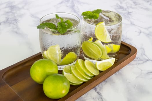 Cold Drink from Lemon cut into pieces in water glass on wood cup