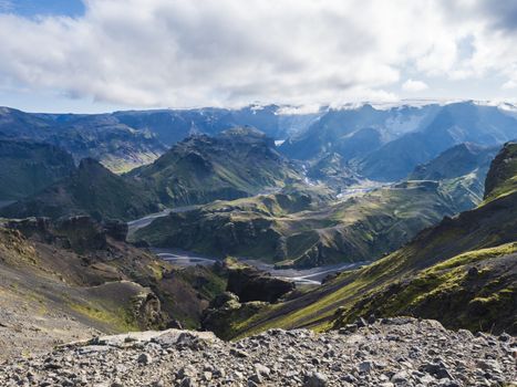 Landscape of Godland and thorsmork with rugged green moss covered rocks and hills, bending river canyon, Iceland, Fimmvorduhals hiking trail. Summer blue sky white clouds.