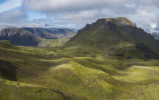 Breathtaking view on Landscape of Godland and thorsmork with rugged green moss covered hill and Eyjafjallajokull glacier, Iceland, Fimmvorduhals hiking trail. Summer cloudy day