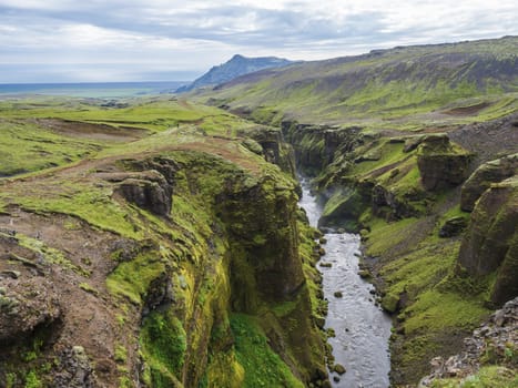 Beautiful lush green Landscape of Skoga river valley cascades near Skogafoss waterfall and Skogar end of Fimmvorduhals hiking trail. South Iceland, Summer blue sky.