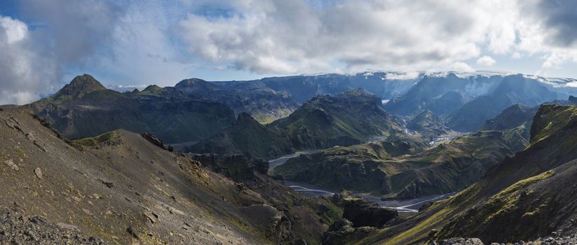 Panoramic breathtaking view on Landscape of Godland and thorsmork with rugged green moss covered rocks and hills, bending river canyon, Iceland, Fimmvorduhals hiking trail. Summer cloudy day