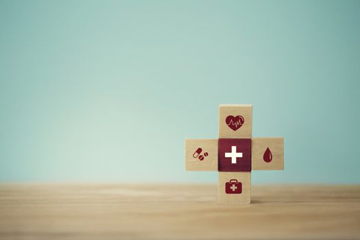 Healthcare concept about of health and medical insurance, arranging wood block stacking with icon healthcare medical on table wooden background.