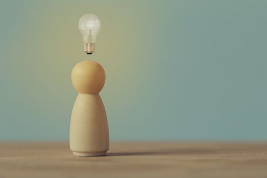 Creative idea and innovation. Human resource and talent management concept: Wood figures of people stand with light bulb glow. Depicts natural abilities to show specialized skills they possess person.