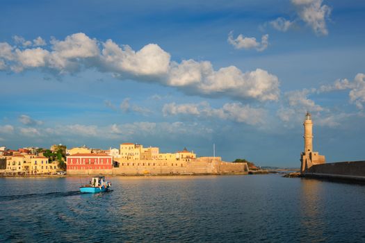 Fishing boat going to sea in picturesque old port of Chania is one of landmarks and tourist destinations of Crete island in the morning. Chania, Crete, Greece