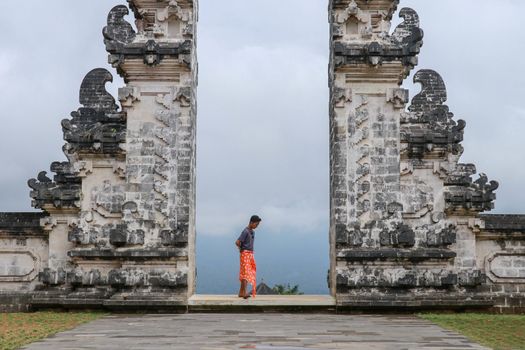 Architecture, traveling and religion. Young traveler enjoying the view in Hindu temple Lempuyang in Bali, Indonesia.