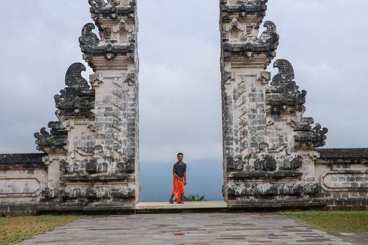 Teenager is standing in the gate of Lempuyang temple on Bali isalnd, Indonesia.