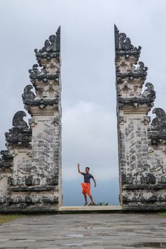 Teenager is standing in the gate of Lempuyang temple on Bali isalnd, Indonesia.