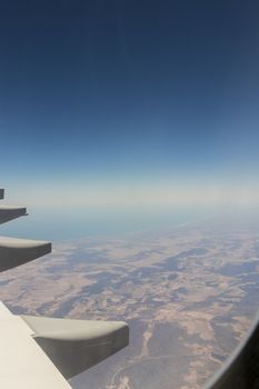 View from an airplane window at high altitude and turbines about South Africa. African Mountains.