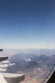 View from an airplane window at high altitude and turbines about South Africa. African Mountains.