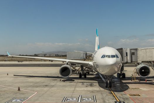 Airplane at the airport in South Africa. Landing and exit of the passengers. Flights and planes in Africa.