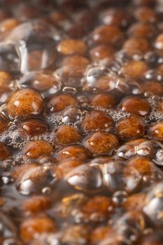 Cooking, boiling brown sugar flavor tapioca pearl balls, ingredient of bubble tea, preparing food and drink, close up, recipe cookbook steps design concept.